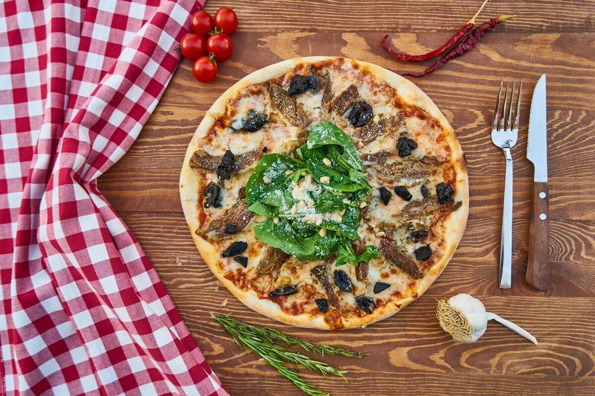Primer plano de pizza sobre mesa de madera